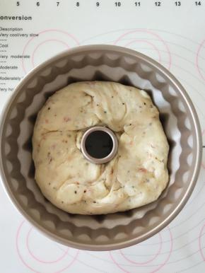         9.在松弛后的面团中间掏洞，放在学厨咕咕霍夫模具中，并将其往底部按几下使其与模具贴紧。