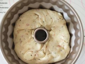         9.在松弛后的面团中间掏洞，放在学厨咕咕霍夫模具中，并将其往底部按几下使其与模具贴紧。