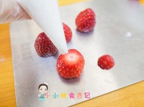 准备一个裱花袋 前面剪一个小口，把草莓帽子取下来把山药挤上去就是雪人的脸蛋