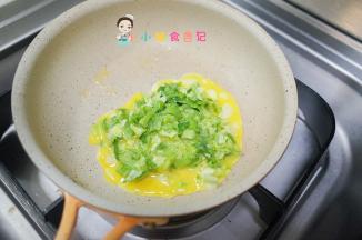 锅里放入一点油倒入青菜鸡蛋，先不要动等稍微有点凝固