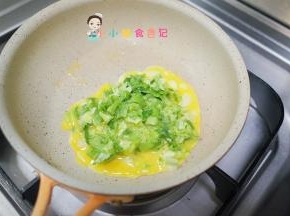 锅里放入一点油倒入青菜鸡蛋，先不要动等稍微有点凝固