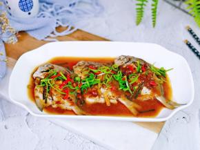 把汤汁淋在鱼身上，撒上葱花，点缀了几段红辣椒。