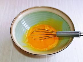 蛋黄用手动打蛋器打散，加入玉米油，抽打融合。