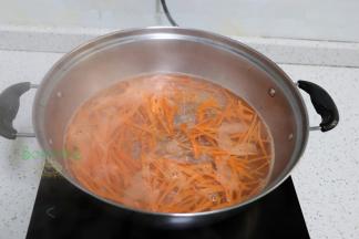 清水煮沸，放入胡萝卜丝，煮熟，然后捞出，沥干水。