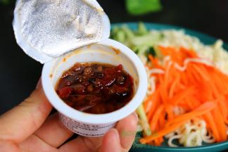 过冷水之后的面条放入盘子里，上面码入烫熟的胡萝卜、还有新鲜的青瓜丝、香葱、拌面酱，搅拌均匀，太好吃了。