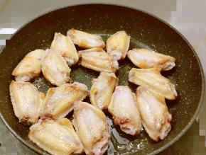 锅中放入食用油 油热后放入腌好的鸡翅中 煎至两面微微焦黄 取出备用