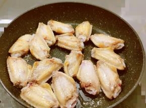 锅中放入食用油 油热后放入腌好的鸡翅中 煎至两面微微焦黄 取出备用
