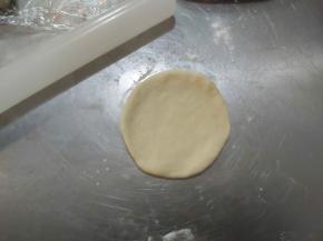 取出一块面团，用擀面杖擀开。