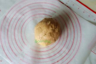 搅拌好的面团分2小团，取一小团放在硅油纸上，然后用擀面杖擀薄至0.5厘米左右。硅油纸的大小和烤盘一致，可以直接放入烤盘。