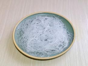 泡发的粉丝均匀铺在盘中。