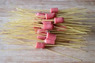 将香肠每根都切成3段，每段都串入4-5根干意面；