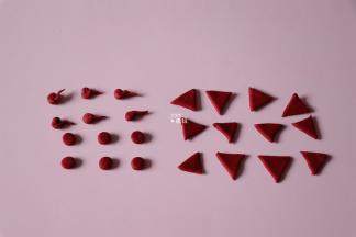 将红色面团擀开，用工具做出小猪的鼻子、耳朵、尾巴；