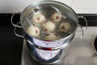 做好的猪猪包下面垫一张油纸，放进事先装好水的雷诺瓦蒸锅里，盖上盖子二次发酵30分钟；