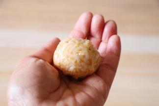 再放一勺米饭，借助保鲜膜整形成圆球；