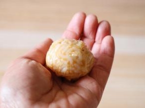 再放一勺米饭，借助保鲜膜整形成圆球；