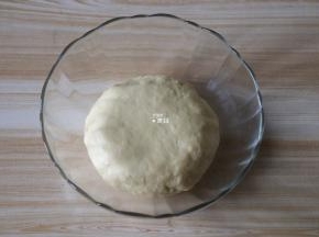 将所有面团材料混合揉成一个光滑不粘手的面团（酵母粉先倒进纯牛奶中搅拌均匀）；