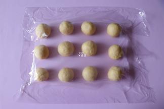 发酵好的面团排气后分成12等份，一一揉圆，盖上保鲜膜松弛15分钟；