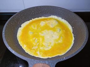 转动锅把鸡蛋液摊成圆形。