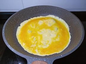 转动锅把鸡蛋液摊成圆形。