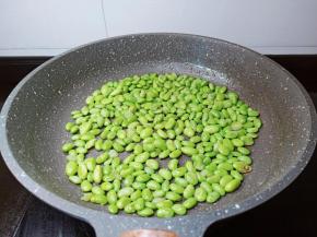 锅里放一点点油，把毛豆炒干水份。