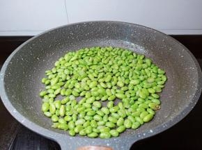 锅里放一点点油，把毛豆炒干水份。