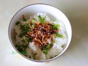 米饭装在一个大盘子里，把虾皮、芝麻、葱白、花生油、盐、五香粉，搅拌均匀。