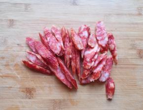 腊肠用水冲一下切成厚一点的片。