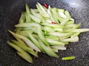 下入芹菜翻炒均匀。