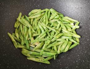 下入豆角翻炒至变色。