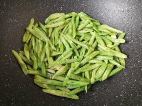 下入豆角翻炒至变色。