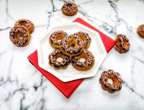 甜甜圈出炉以后晾一下脱模，将原味巧克力放在小碗里隔水融化，拿起甜甜圈轻轻蘸一下，草莓巧克力装入裱花袋融化，挤在原味巧克力上面，撒上糖珠，自然晾干即可。