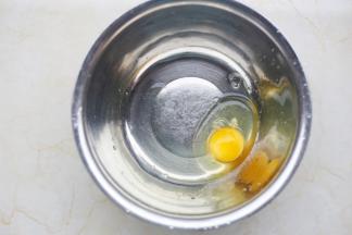 鸡蛋磕入大盆中。