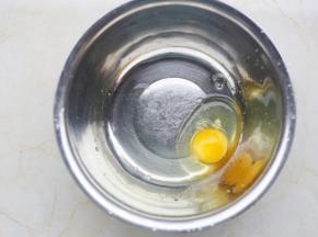 鸡蛋磕入大盆中。