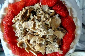 把草莓块摆在蛋糕面上，中间撒蛋卷碎即可。