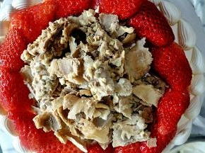 把草莓块摆在蛋糕面上，中间撒蛋卷碎即可。