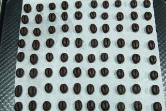 然后分3克一个小面团，搓成椭圆形小面团，排入铺好油纸的烤盘上，间隔一些距离。用刮板或者脱模刀尖在面团中部按压一下，压出一条缝隙，不要把面团压断哈。