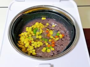 煮粥30分钟时米已经软糯啦！加入时蔬玉米片，煮20分钟，最后提前5分钟加入腌制好的虾仁，待饭煲滴的一声，会自动进入保温状态，这时就可以断电啦。