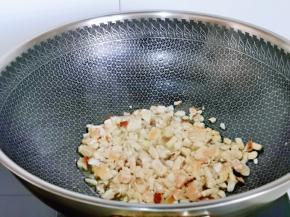 起油锅，加入切好的鸡丁，香菇丁煸炒，炒制变色，加入一小勺料酒小火翻炒。