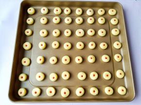 搓成圆形放烤盘里，用筷子扎一下再挤上草莓酱。