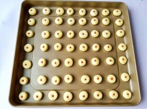 搓成圆形放烤盘里，用筷子扎一下再挤上草莓酱。