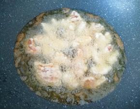 炒锅内倒多一些花生油烧热，下入肉块中小火炸制。