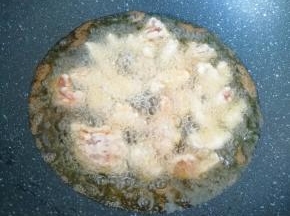 炒锅内倒多一些花生油烧热，下入肉块中小火炸制。