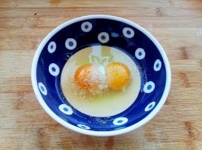 鸡蛋磕入碗中，加入盐、胡椒粉搅拌均匀。