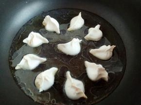 底部微定型后加入热水，水量没过饺子1/3处就可以。盖盖中小火焖煮。
