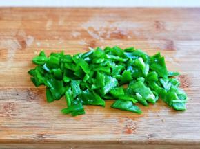 首先将青椒洗干净，切去根，去籽，再切小块。