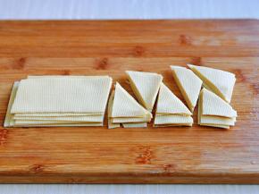 干豆腐切长条，叠加再一起，切出菱形块。