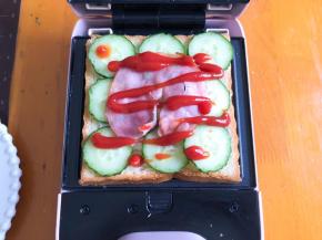 挤上番茄酱，再放上一片吐司，盖上盖子煎3分钟