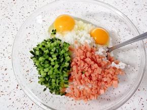 把切好的黄瓜火腿肠丁放进米饭里，打入两个土鸡蛋（用土鸡蛋煎出来的米饼色泽更好一些）。