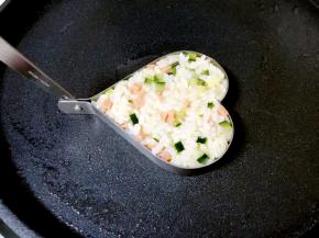 用勺子把米饭放进煎蛋模具里面压平，启动电饼铛。