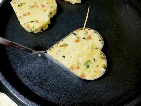 待到米饼两面都定型以后，用牙签在煎蛋模具的边缘轻轻划一圈。